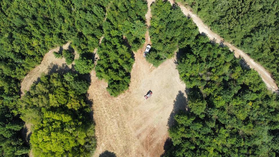 Aerial of a cleared pad and truck in the woods