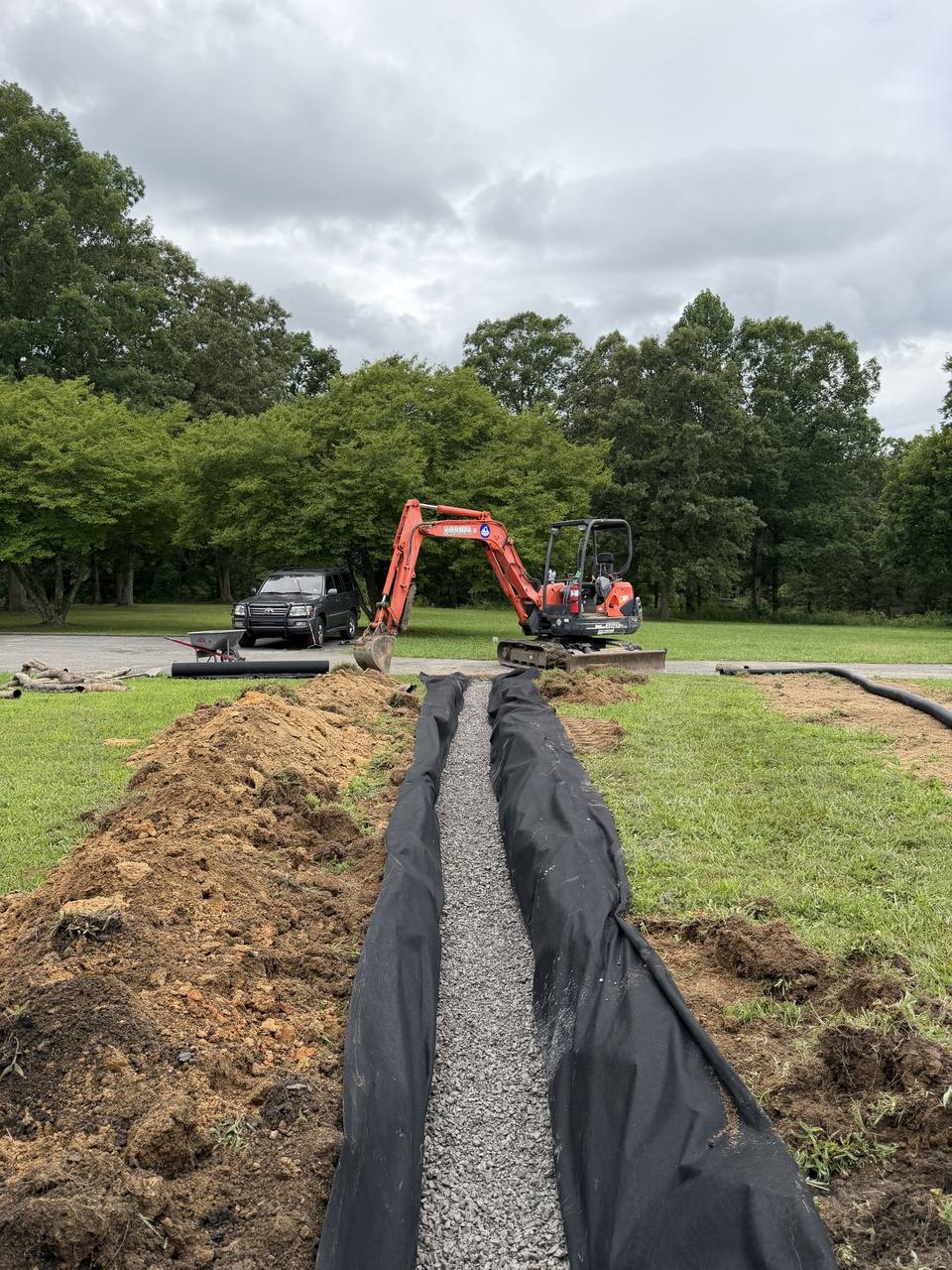 Trench for a French drain running to the excavator