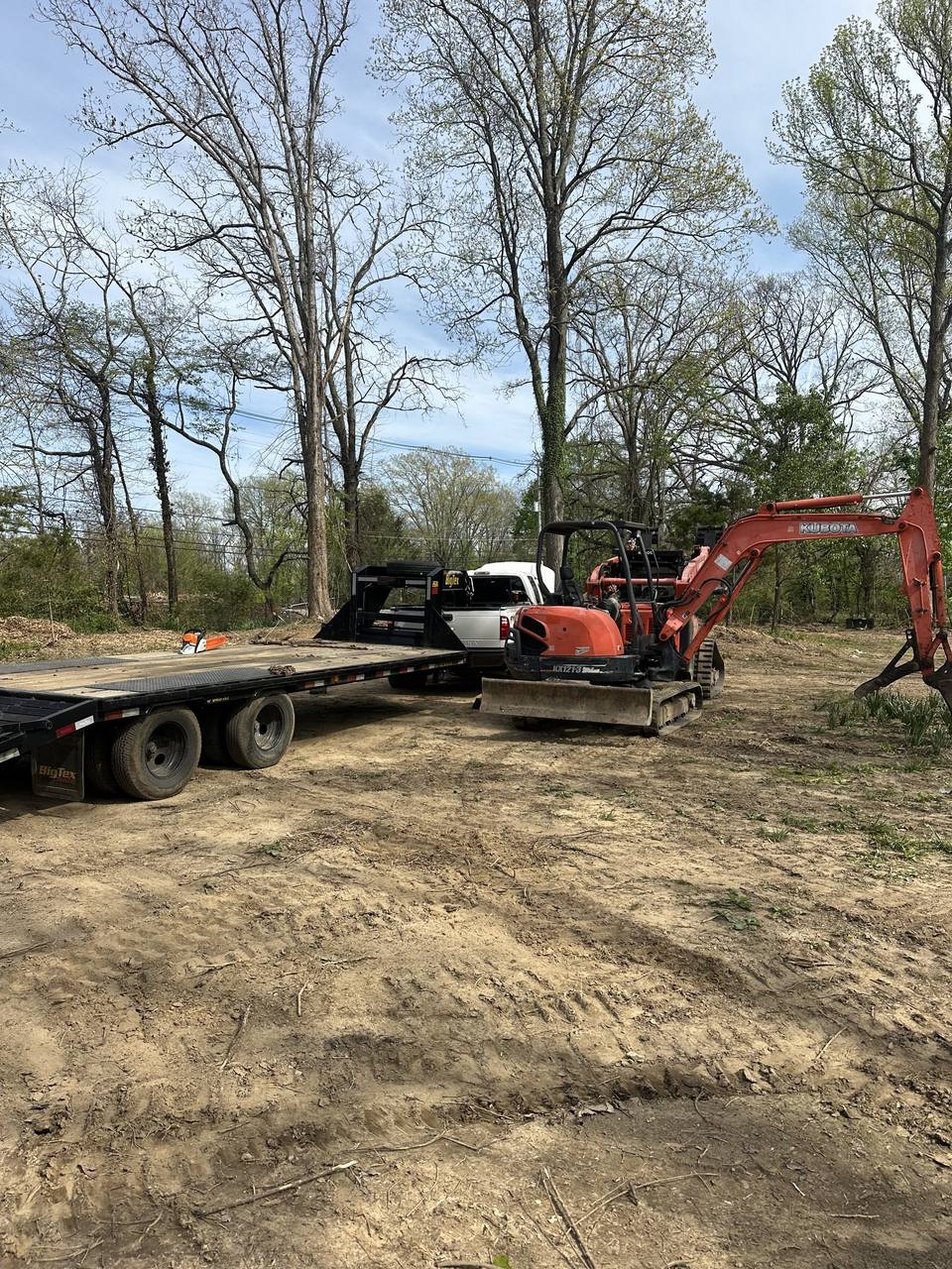 Excavator and trailer on a cleared lot