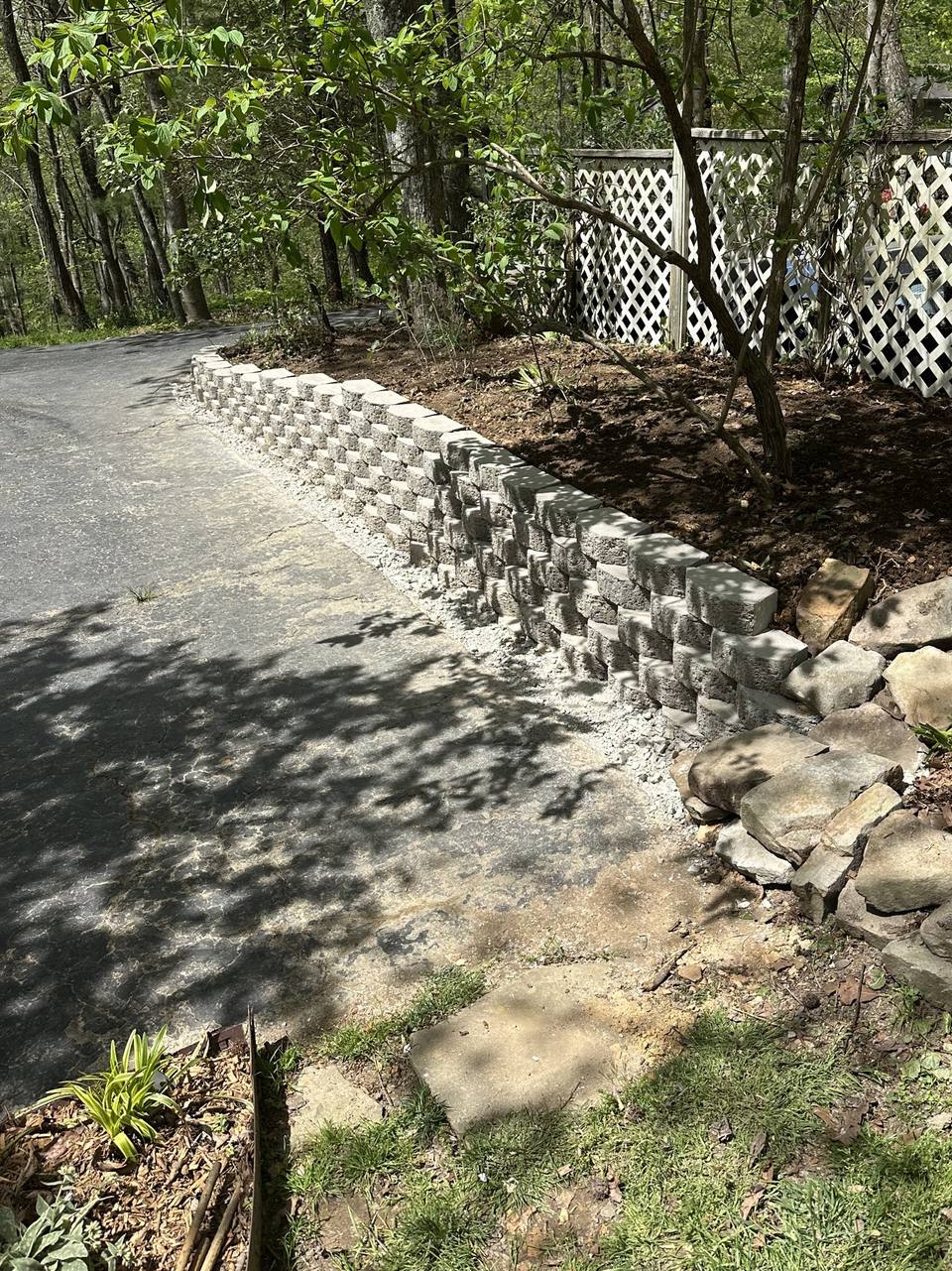 Finished block retaining wall with stone along a drive