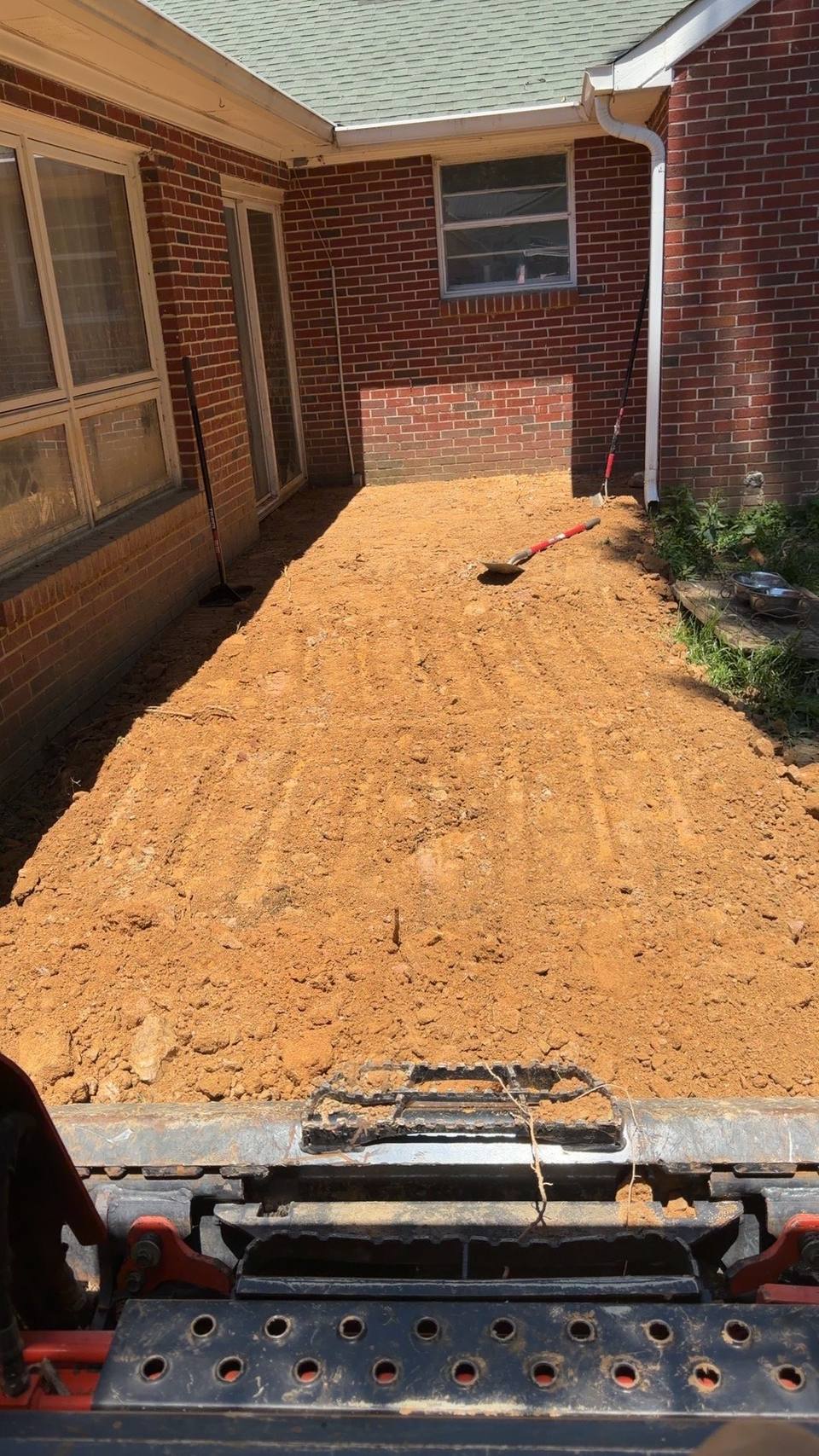 Graded pad along a brick wall