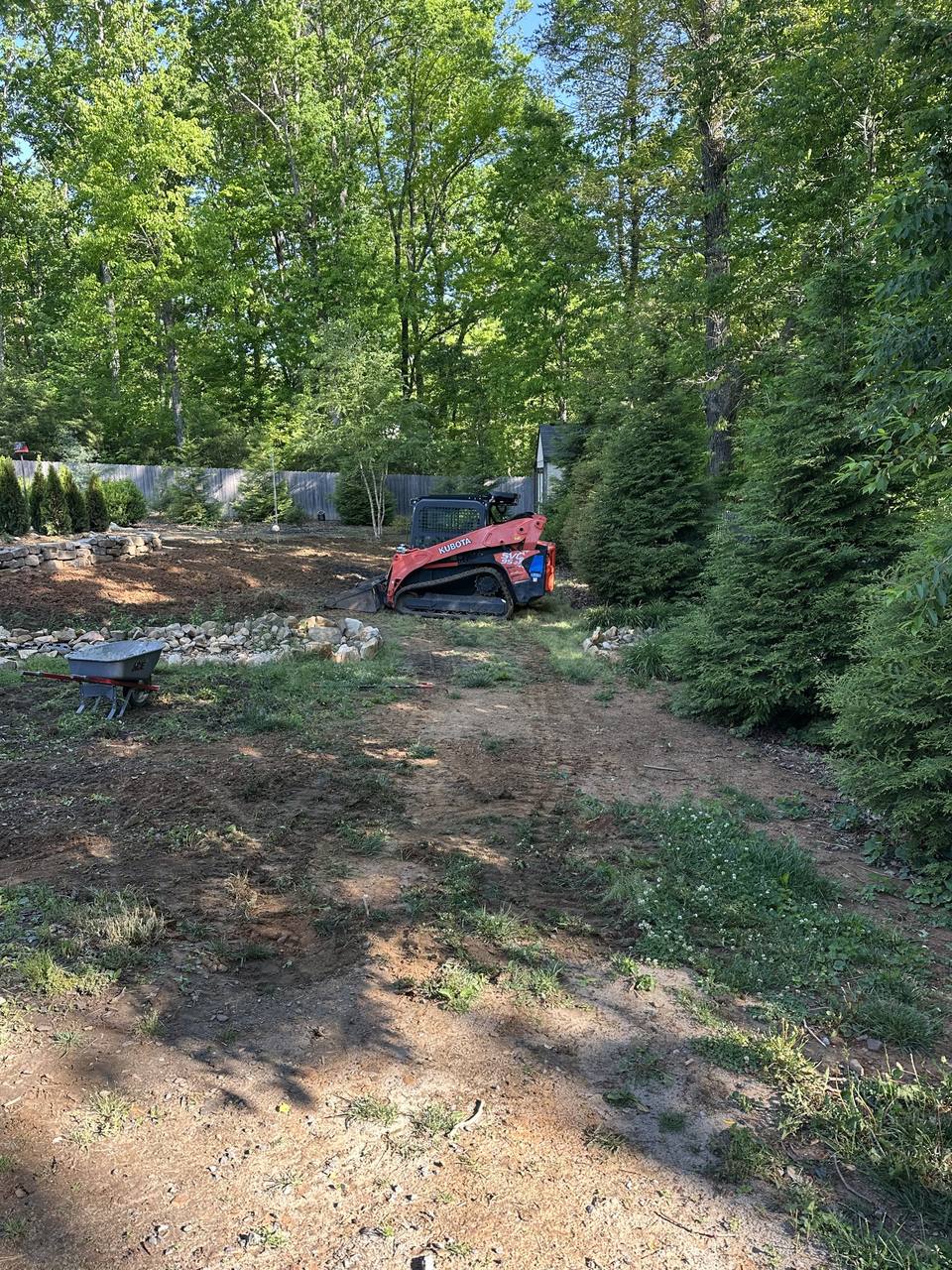 Track loader on a back yard graded to bare dirt before sod