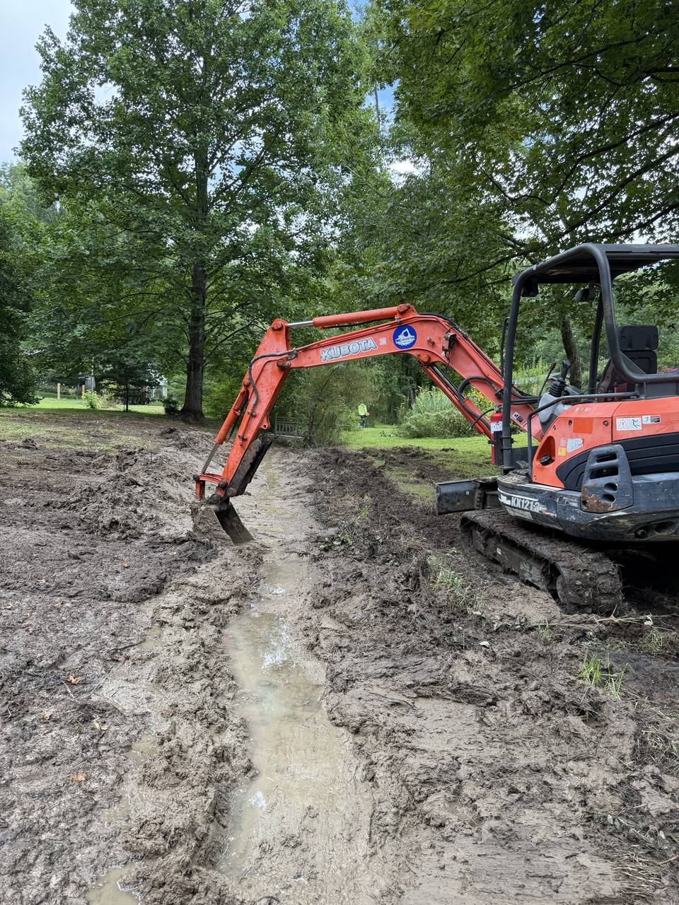 Mini excavator digging a drainage ditch