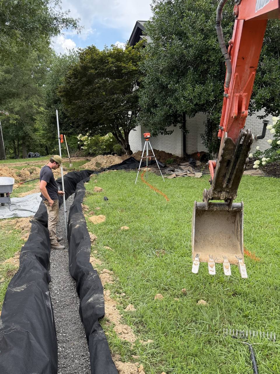 French drain trench lined with fabric and gravel