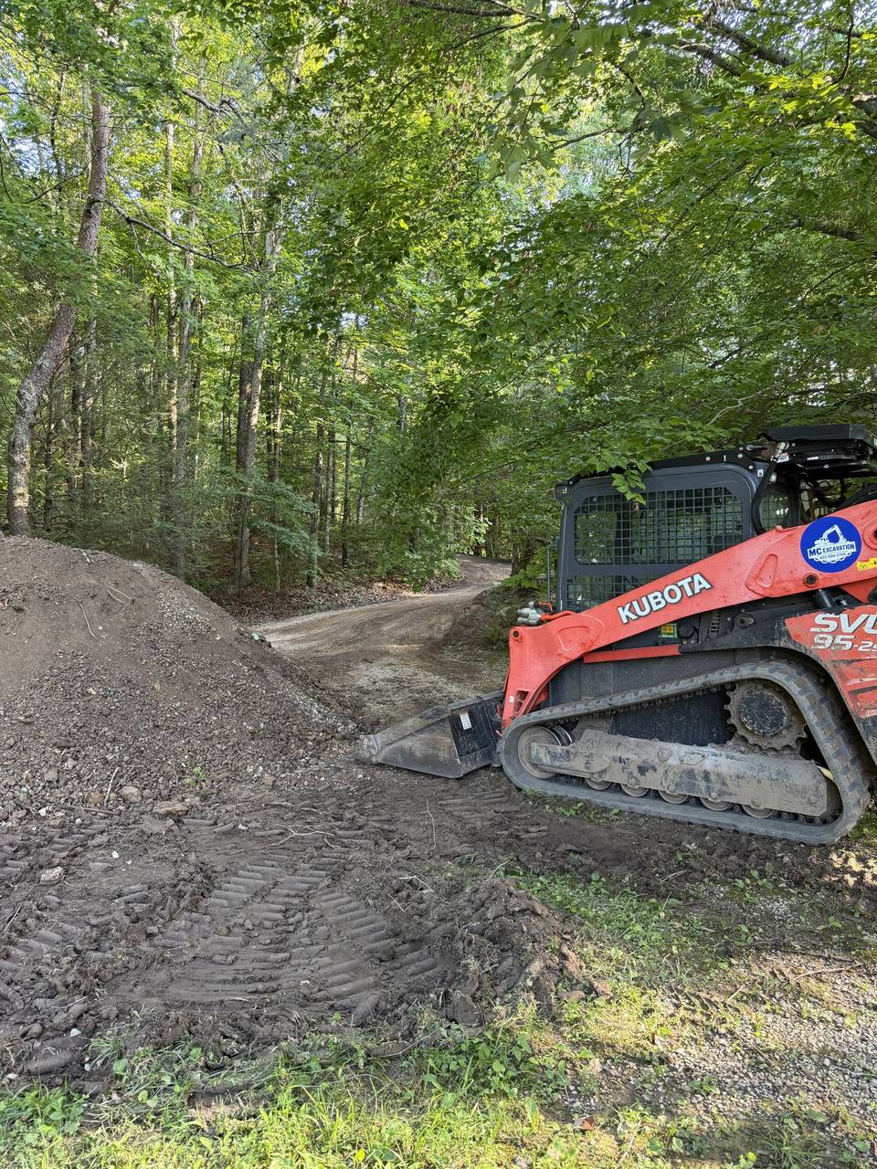 Track loader working a gravel pile on a drive
