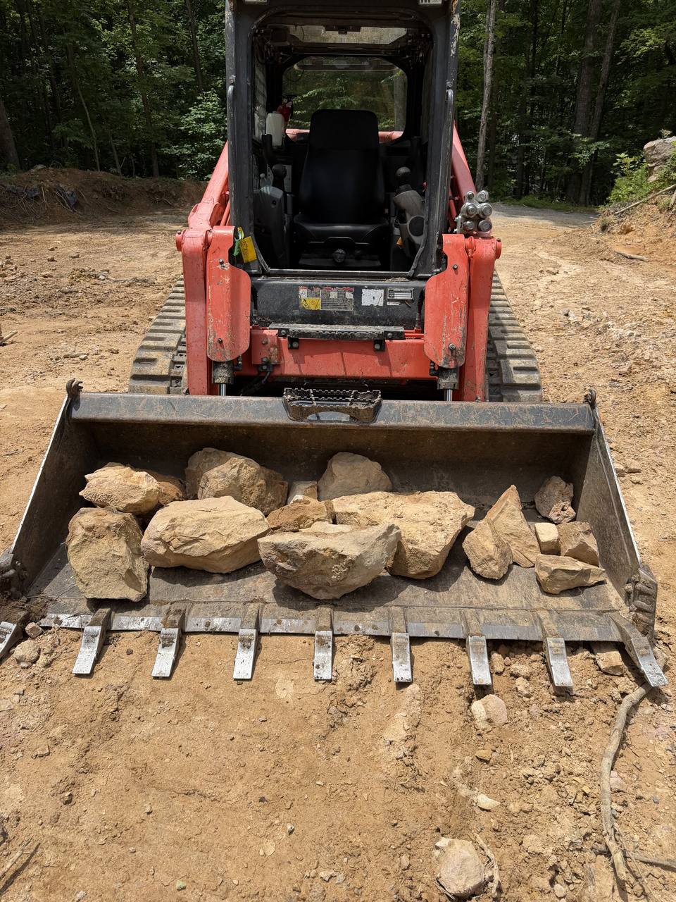 Track loader bucket full of dug rock
