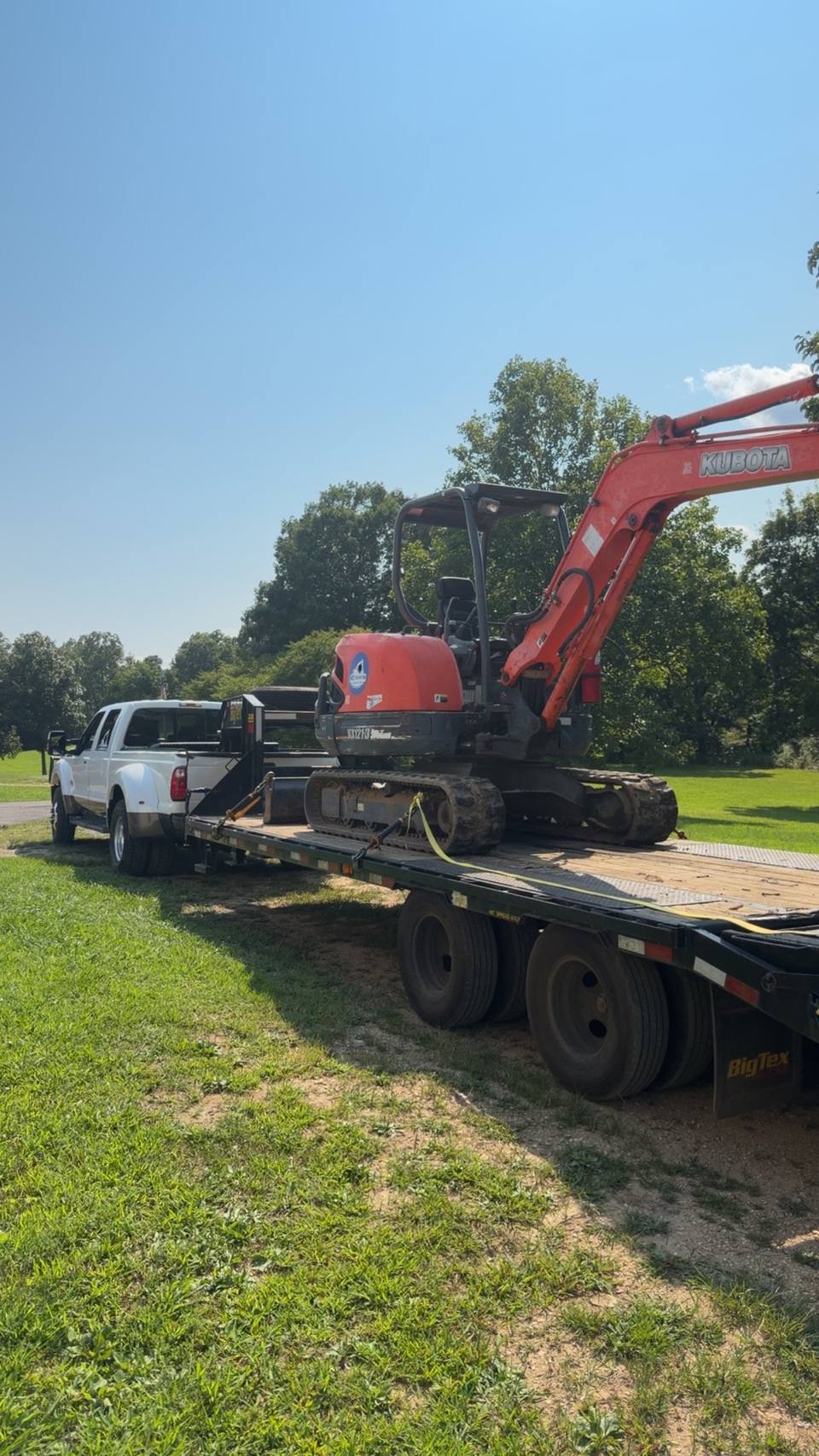 Truck and trailer loaded with a mini excavator